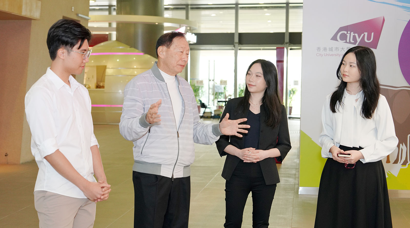 Three CB undergraduate student representatives show Dr Peter Wong (second left) around the CityU campus