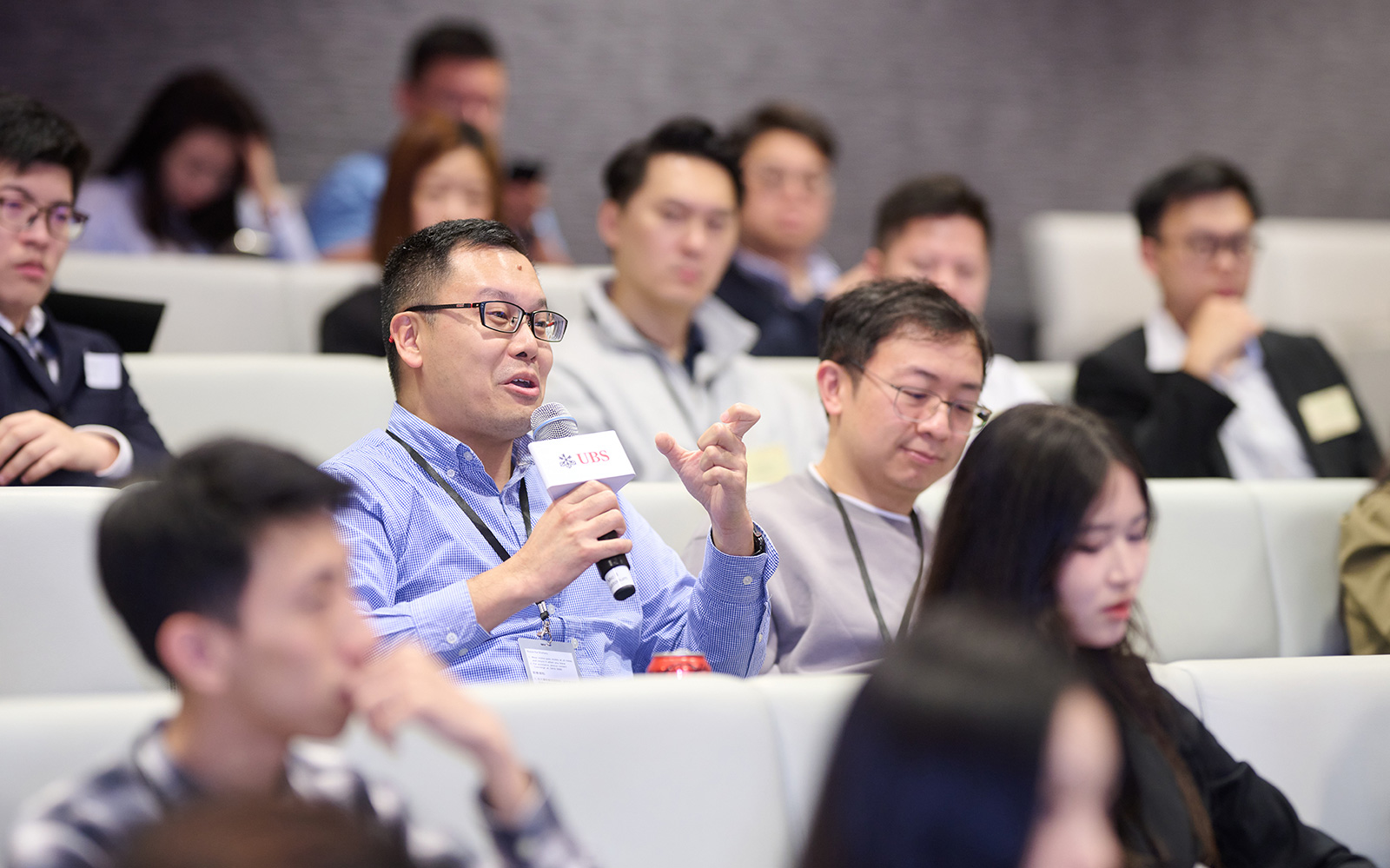 An MBA alumnus poses questions to the speakers during the Q&A session