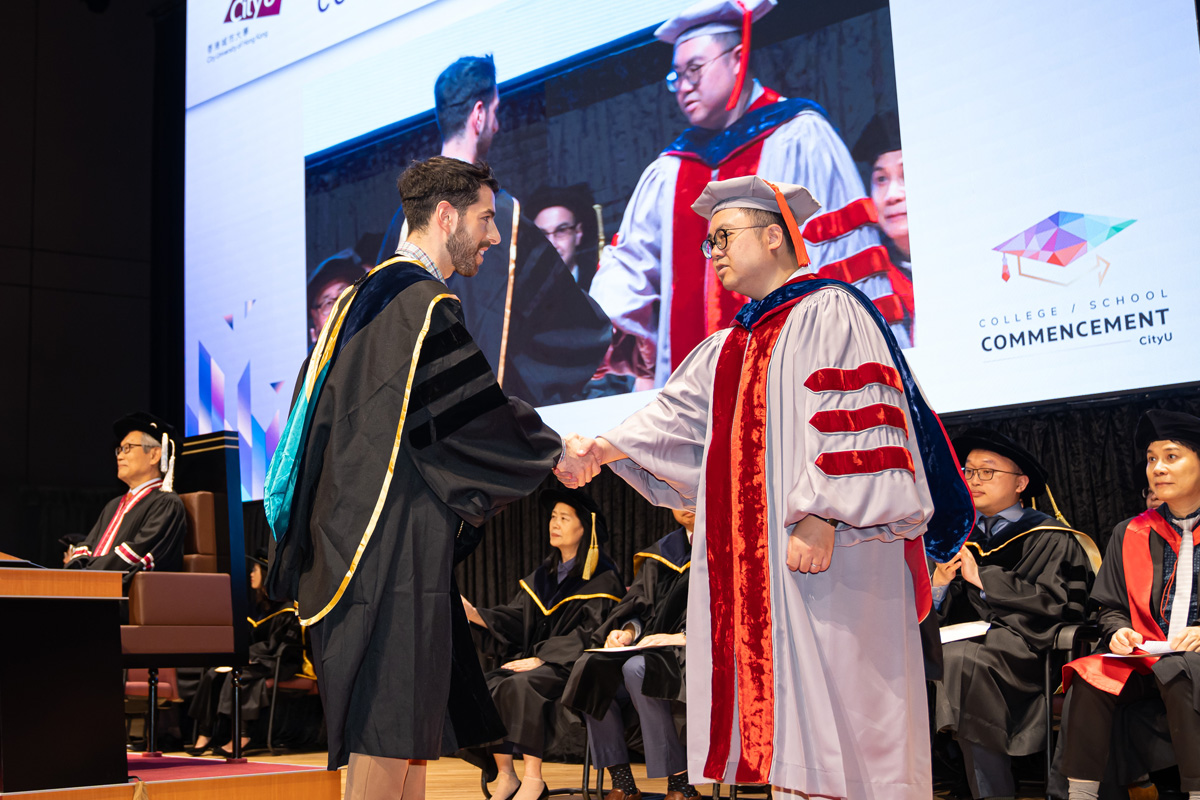 Professor Stephen Shum, Associate Dean (Research & Faculty), congratulates a PhD graduate