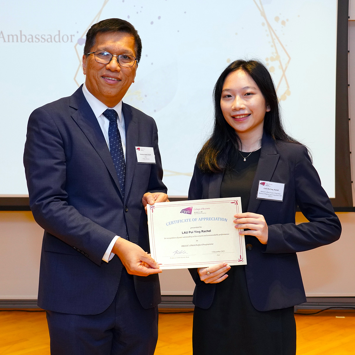 Dean Chan (left) presents a certificate of appreciation to Rachel Lau (BBA Global Business) who championed in the HKGCC Pitch Perfect Programme