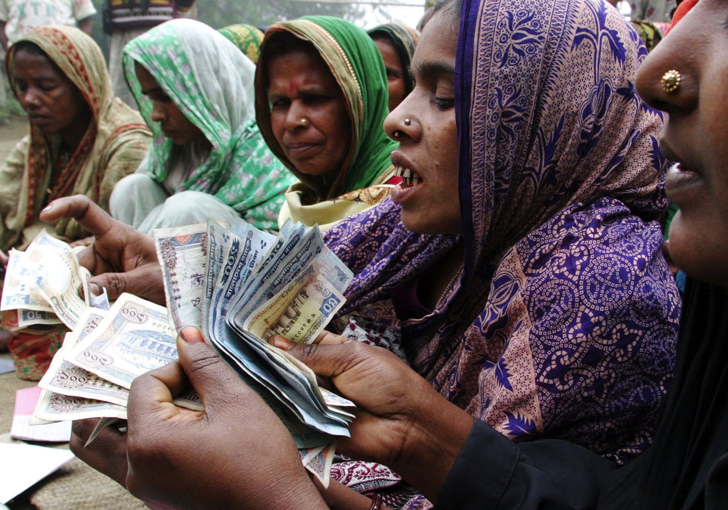 Women count money for repayment to a microcredit bank near Dhaka, Bangladesh ©REUTERS/Rafiqur Rahman NA/SH